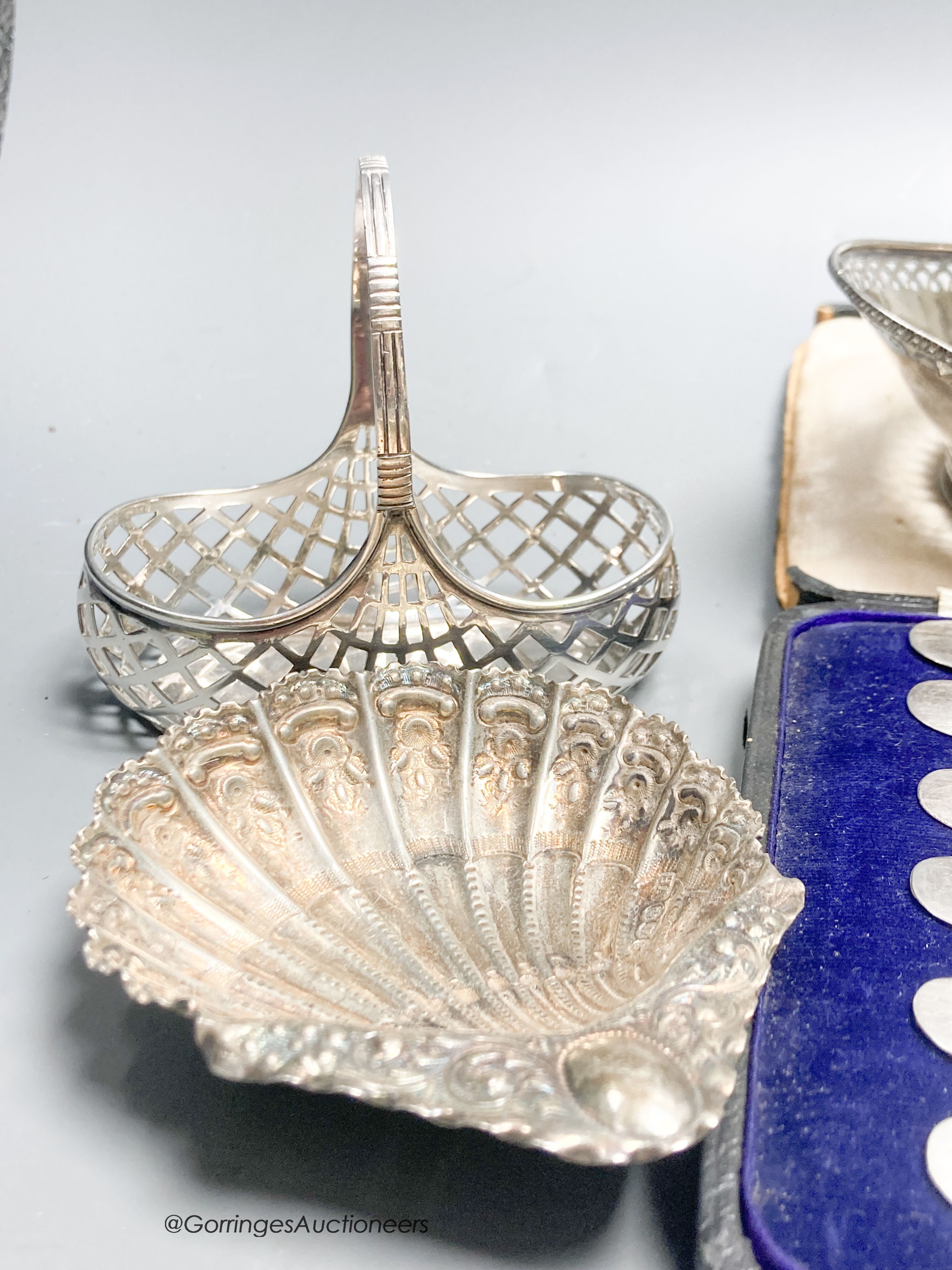 A George V silver two handled butter dish, with blue glass liner, a white metal basket, a pair of Victorian shell dishes, a French white metal dish, white metal toast rack and cased tea knives.